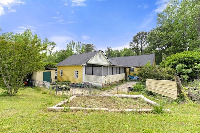 exterior space with a sunroom, an outbuilding, and fence