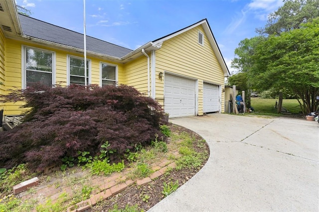 view of property exterior featuring driveway and a garage