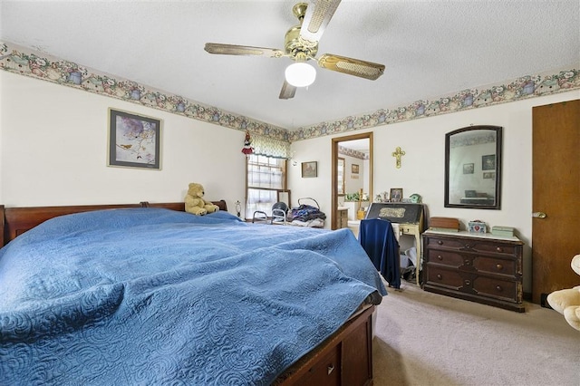 bedroom featuring carpet flooring, ensuite bathroom, and a ceiling fan