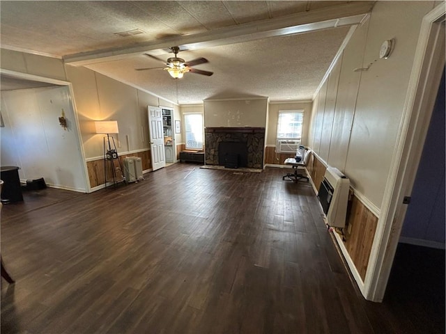 unfurnished living room featuring dark hardwood / wood-style floors, a textured ceiling, heating unit, ceiling fan, and a fireplace