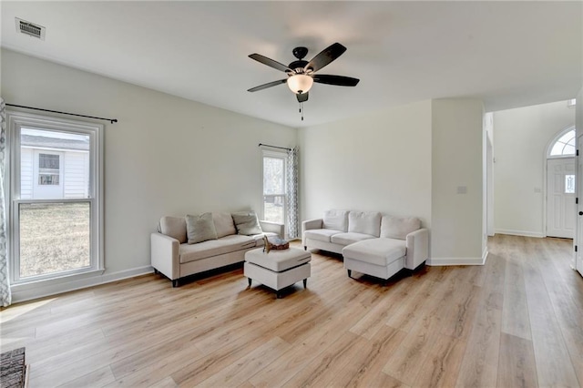 living area with plenty of natural light, light wood-type flooring, and ceiling fan