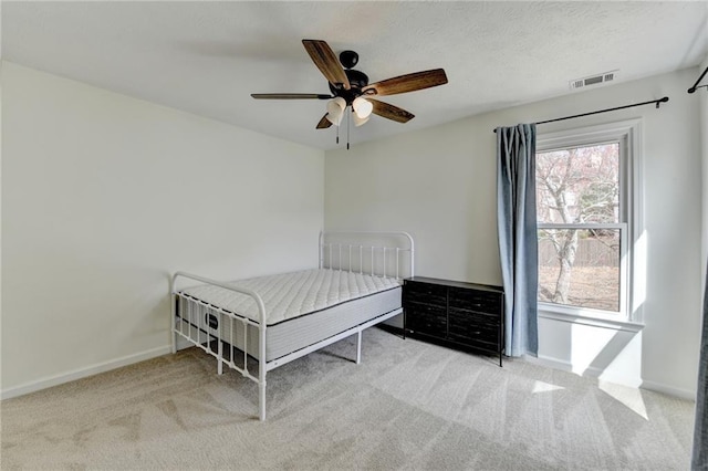 unfurnished bedroom featuring visible vents, carpet flooring, a ceiling fan, and baseboards