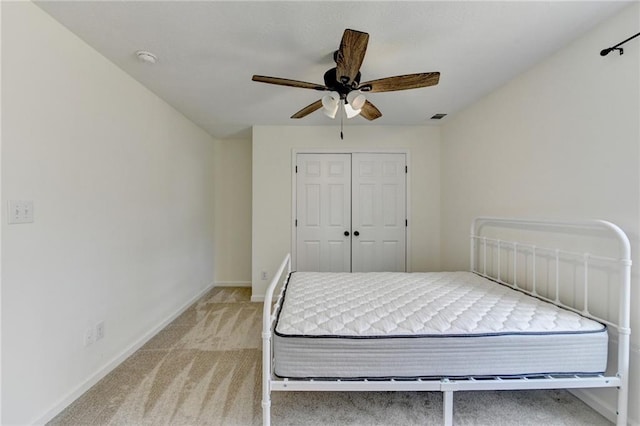 carpeted bedroom featuring visible vents, a ceiling fan, baseboards, and a closet