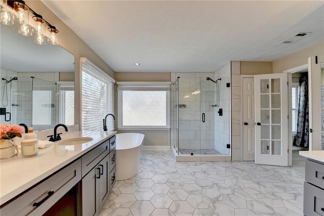 full bathroom featuring visible vents, a freestanding bath, a stall shower, and vanity