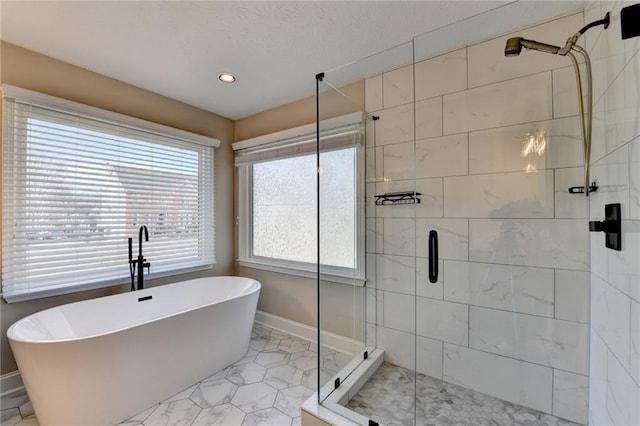 full bathroom with baseboards, a freestanding bath, and a stall shower