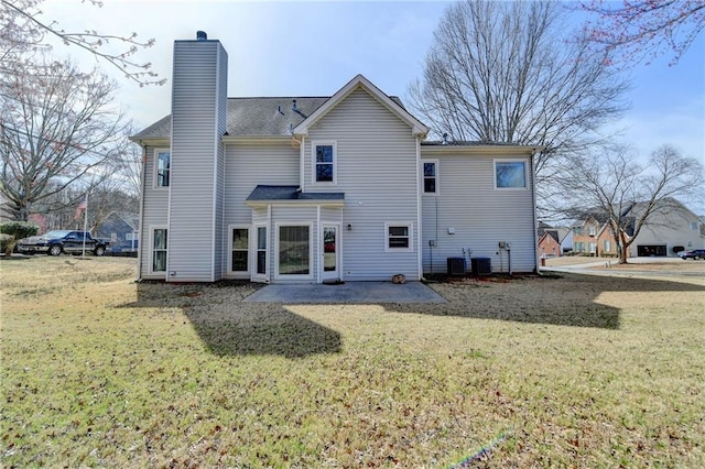 back of property featuring a yard, central AC, a chimney, and a patio area