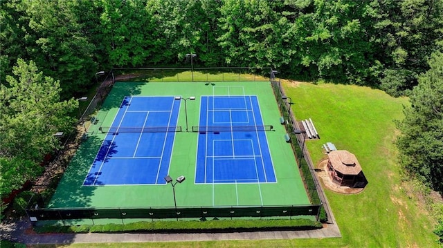 view of sport court featuring a yard and fence