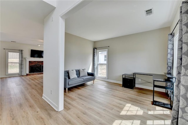 interior space featuring a wealth of natural light, visible vents, light wood finished floors, and a fireplace