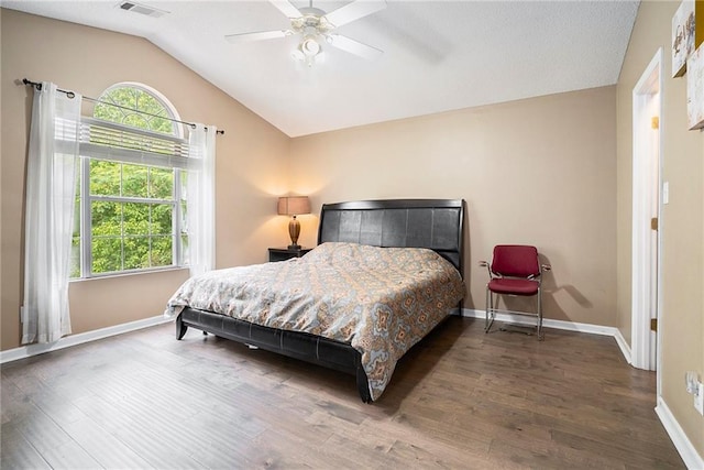 bedroom featuring wood finished floors, vaulted ceiling, baseboards, and a ceiling fan