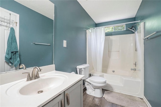 full bathroom featuring shower / bath combo with shower curtain, toilet, vanity, wood finished floors, and a textured ceiling