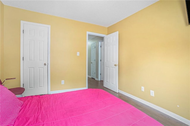 bedroom featuring baseboards and wood finished floors