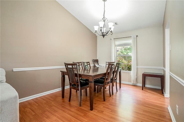 dining area with a chandelier, light wood finished floors, and baseboards
