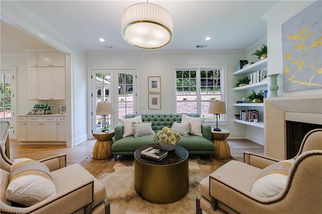 living area with crown molding, a fireplace, and a healthy amount of sunlight
