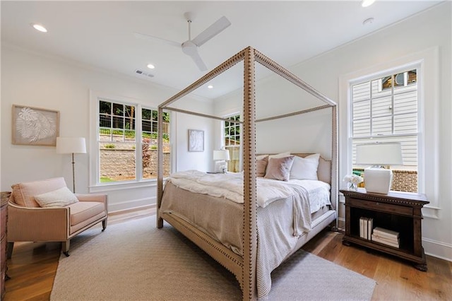 bedroom with visible vents, crown molding, baseboards, recessed lighting, and wood finished floors
