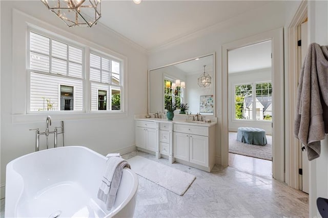 bathroom featuring a notable chandelier, ornamental molding, a sink, double vanity, and a soaking tub