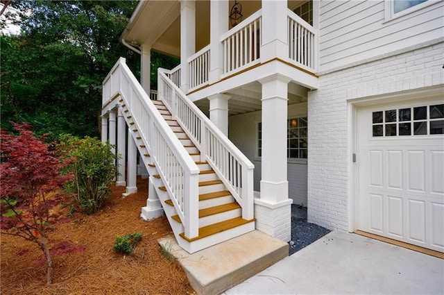 doorway to property featuring a garage and brick siding