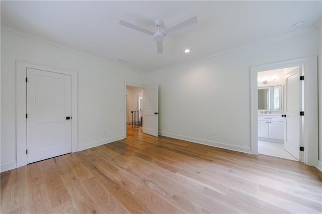 unfurnished bedroom with ensuite bathroom, crown molding, light wood-type flooring, and baseboards