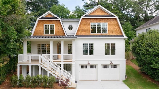 shingle-style home featuring a standing seam roof, stairs, covered porch, and a gambrel roof