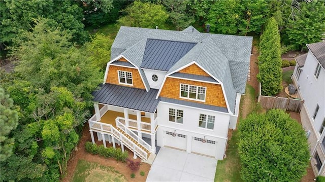 view of front of house featuring a gambrel roof, driveway, a standing seam roof, metal roof, and stairs