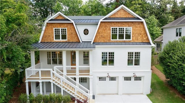 shingle-style home featuring a gambrel roof, a porch, stairs, and a standing seam roof