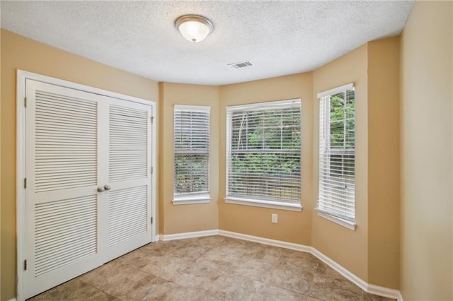 unfurnished bedroom featuring a closet and a textured ceiling