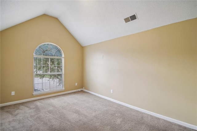 carpeted empty room with lofted ceiling