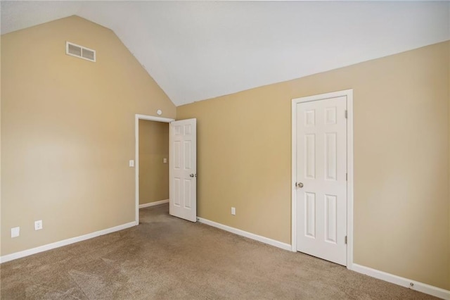 carpeted spare room with high vaulted ceiling