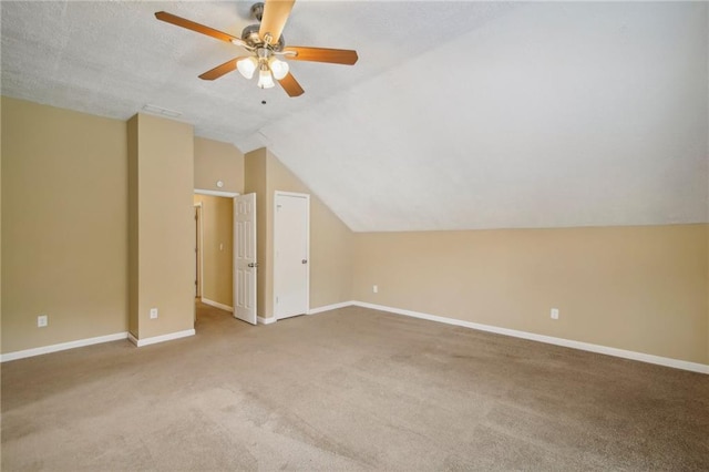 bonus room with lofted ceiling, a textured ceiling, light colored carpet, and ceiling fan