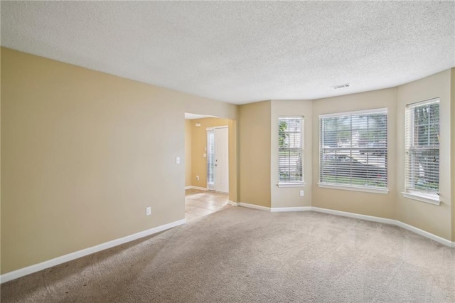 carpeted spare room featuring a textured ceiling