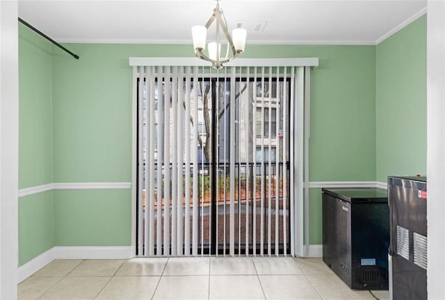 unfurnished dining area with ornamental molding, tile patterned flooring, and a notable chandelier