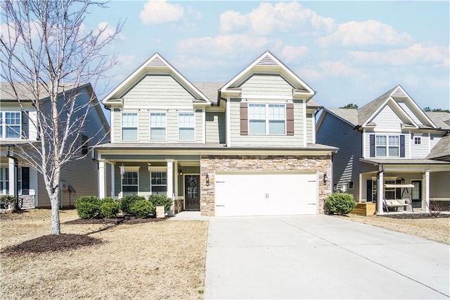 craftsman-style home featuring stone siding, a porch, an attached garage, and driveway