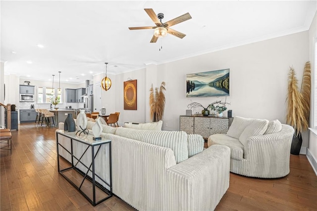 living room with ceiling fan, dark wood finished floors, crown molding, and recessed lighting