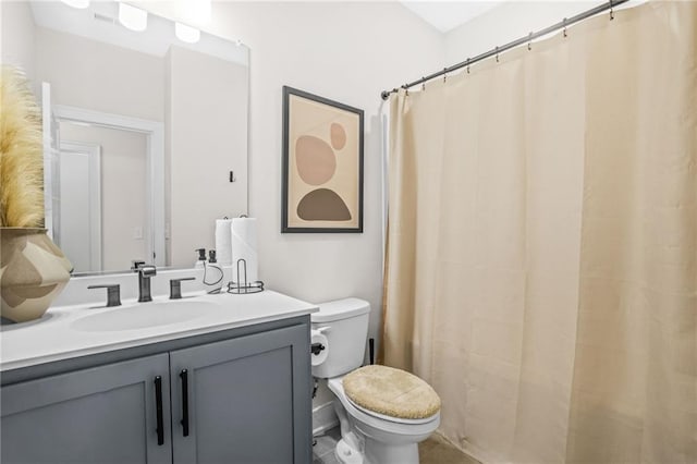 bathroom featuring toilet, vanity, and curtained shower