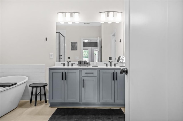bathroom with a shower stall, double vanity, and a soaking tub