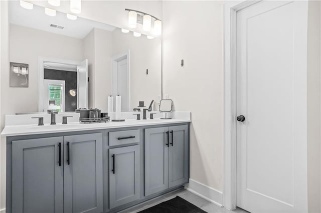 full bathroom with double vanity and baseboards