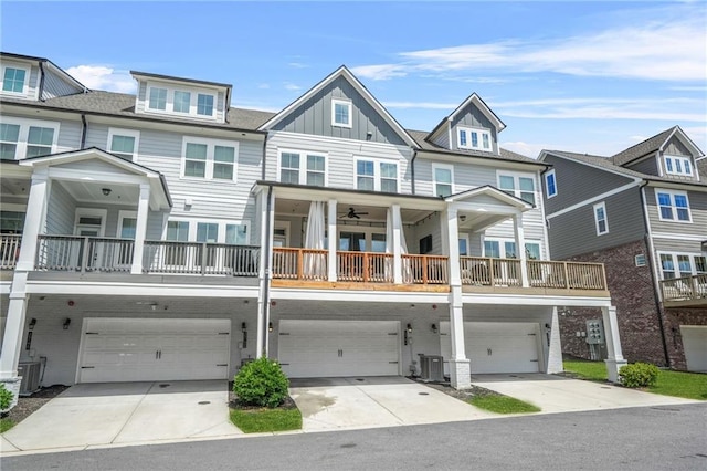 multi unit property with board and batten siding, an attached garage, central AC unit, and driveway
