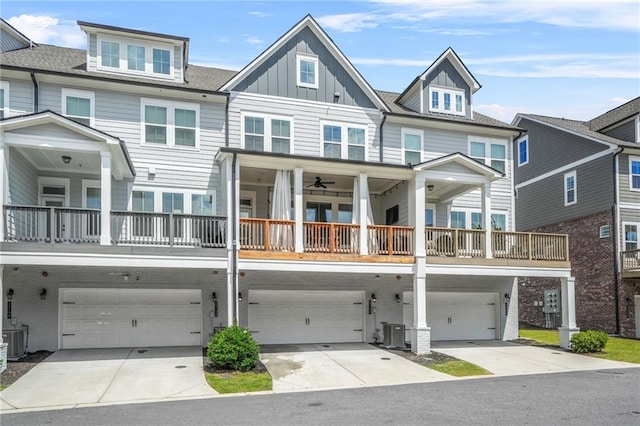 view of front facade featuring an attached garage, central AC unit, board and batten siding, and driveway