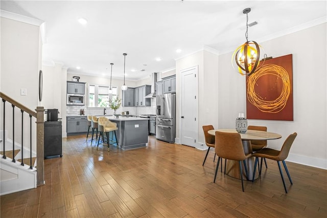 dining space featuring stairs, dark wood-type flooring, ornamental molding, recessed lighting, and baseboards