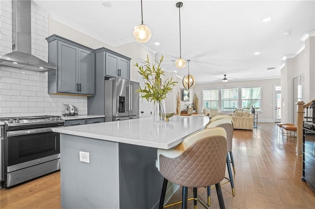 kitchen featuring stainless steel appliances, wall chimney exhaust hood, crown molding, ceiling fan, and decorative backsplash