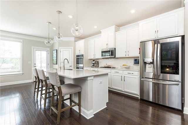3133 Quinn Pl, Atlanta, GA 30341 - kitchen featuring appliances with stainless steel finishes, crown molding, a sink, an island with sink, and light countertops