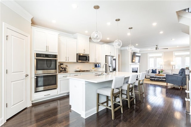 3133 Quinn Pl, Atlanta, GA 30341 - kitchen featuring stainless steel appliances, a sink, a breakfast bar, a center island with sink, and light countertops