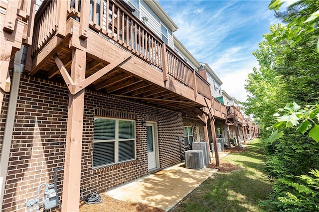 3133 Quinn Pl, Atlanta, GA 30341 - view of home's exterior featuring brick siding, a wooden deck, a patio area, and cooling unit