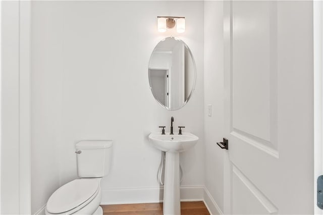 bathroom with toilet and wood-type flooring