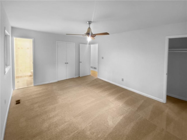 unfurnished bedroom featuring carpet flooring, baseboards, ensuite bathroom, and a closet