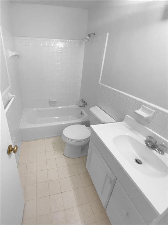 full bathroom with toilet, washtub / shower combination, vanity, tile walls, and tile patterned floors
