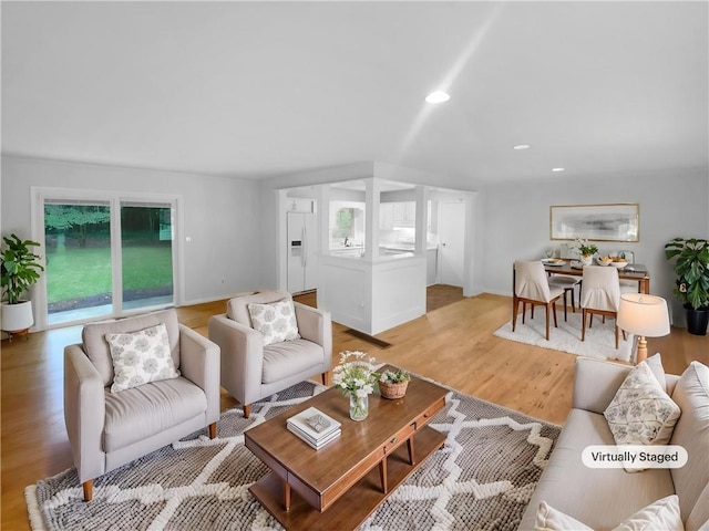 living area featuring recessed lighting, light wood-type flooring, and baseboards
