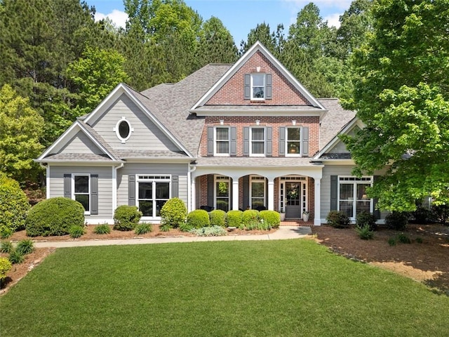 craftsman-style house with brick siding and a front yard