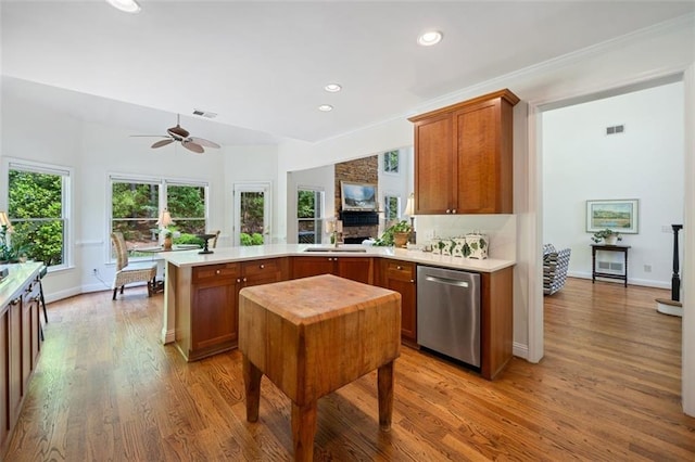 kitchen featuring visible vents, a sink, a peninsula, a ceiling fan, and dishwasher
