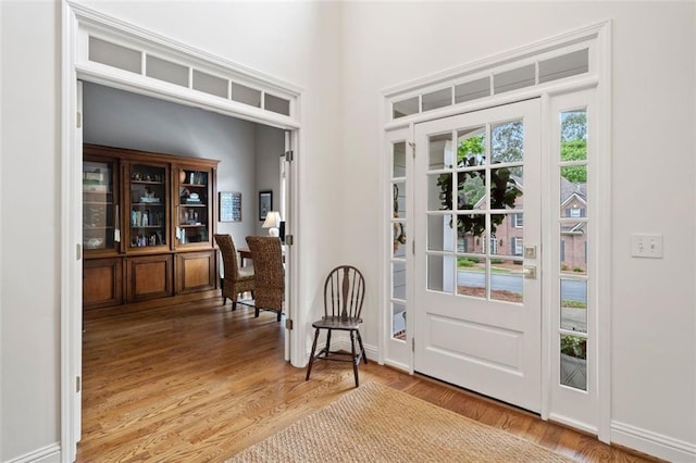 doorway to outside with baseboards and wood finished floors