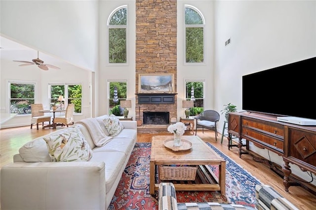 living area featuring visible vents, a healthy amount of sunlight, and a towering ceiling
